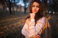 Sunset portrait of beautiful brunette young woman in autumn park