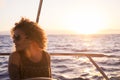 Sunset portrait of beautiful long hair caucasian woman on a sail boat enjoying the feeilng and the freedom with ocean around and Royalty Free Stock Photo