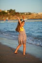 Sunset portrait of a happy dancing caucasian girl  in summer dress at the seashore Royalty Free Stock Photo