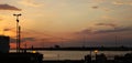 Sunset on the waterfront with the lampposts of the harbor in backlight Royalty Free Stock Photo