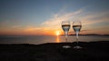 Sunset at the ramparts of alghero city with silhouette with two glasses of prosecco