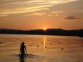 Sunset on RAquette Lake. Woman walking. Royalty Free Stock Photo