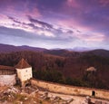Sunset at Rasnov medieval citadel in Transylvania. Panoramic view of the defense wall and mountains in the horizon