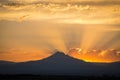 Sunset rays behind silhouette of mountain Royalty Free Stock Photo