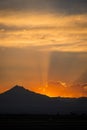 Sunset rays behind silhouette of mountain Royalty Free Stock Photo