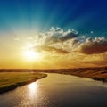 Sunset with rays in clouds over river Royalty Free Stock Photo
