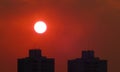 Sunset on red sky over buildings in autumn