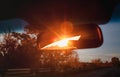 Sunset red sunbeams in a salon inside rearview mirror of a car. Close-up, blur Royalty Free Stock Photo