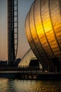 Sunset Reflected on the Curved Exterior of the Science Centre and in Ripples on a Pond in the Foreground in Glasgow Scotland
