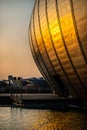 Sunset Reflected on the Curved Exterior of the Science Centre and in Ripples on a Pond With a Paddle Steamer on The River Clyde