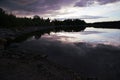 The sunset is reflected in the water by the lake