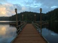 Sunset reflecting on a calm lake with deck in the foreground