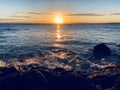 Sunset reflecting on the ocean with waves on the shore