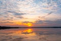 Sunset reflection lagoon. beautiful sunset behind the clouds and blue sky above the over lagoon landscape background. dramatic sky Royalty Free Stock Photo