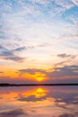 Sunset reflection lagoon. beautiful sunset behind the clouds and blue sky above the over lagoon landscape background. dramatic sky Royalty Free Stock Photo