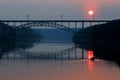 Sunset on the river, sun path and silhouette of people in a boat. railway bridge over the river in summer Royalty Free Stock Photo