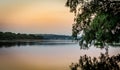 Sunset on the river with tree reflection Royalty Free Stock Photo