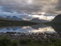 Sunset at rocky grassy shore of Tarra river. Tarraatno with green hills, birch forest and mountians at Padjelantaleden Royalty Free Stock Photo