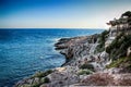 Sunset on a romantic rocky cliff near the clear sea. Royalty Free Stock Photo