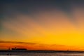 Sunset with sailboat and container ship on the horizon Royalty Free Stock Photo