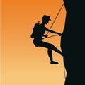 Sunset scene of black silhouette man mountain descent with harness rock climbing Royalty Free Stock Photo