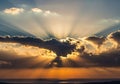 Sunset scene with dramatic sunbeams emerging from behind Royalty Free Stock Photo