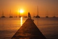 Sunset scene with standing man silhouette with the bicycle on the pier Royalty Free Stock Photo