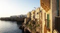 Sunset scenery with overhanging old town of Polignano a mare on cliffs rocks on Mediterranean sea, Apulia, Italy