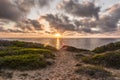 Sunset at scenic Scivu beach - Sand dunes with myrtle vegetation with the ocean in the background and sun-drenched clouds, Sardini Royalty Free Stock Photo