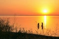 Sunset on the Sea of Azov, two female silhouette in water Royalty Free Stock Photo