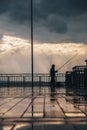 Sunset on a sea bridge after rain in Bulgaria. Reflections on ground. Amazing sea landscape. Fisherman waiting for fish. Royalty Free Stock Photo