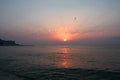 Sunset at sea late in the evening. The red-pink rays of the sun and the blue sea. Beautiful landscape of the summer ocean. Dawn,