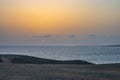 Sunset in the sea with lighthouse and boat Royalty Free Stock Photo