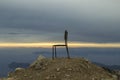 Sunset on the sea with pouring bright sun rays through the clouds. A chair on top of a mountain