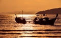 Sunset sea shore with long tail boat silhouettes Royalty Free Stock Photo