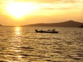 Sunset on the sea with single fishing boat in an orange scenery