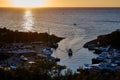 Sunset at sea, the sun sets over the horizon. The ship enters the bay, the sun`s rays are reflected in the water Royalty Free Stock Photo