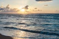 Sunset at the sea. Turquoise water in the ocean in the evening. Yellow sky with small clouds and blue waves at sandy beach at the Royalty Free Stock Photo