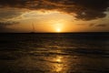 Sunset seascape with boat on horizon under orange sky Royalty Free Stock Photo