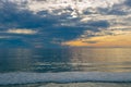 Sunset seascape, orange, blue, yellow sky, with aqua marine green sea, white waves rolling in, pacific ocean, background photo of Royalty Free Stock Photo