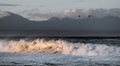 Sunset Seascape. Powerful ocean wave on the surface of the ocean. Wave breaks on a shallow bank. Stormy weather, stormy clouds sky