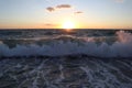 Storm on the beach, wave and sea foam against the background of the sun and sky, Italy, Calabria Royalty Free Stock Photo