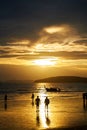 Sunset on the seashore.People are looking for beautiful shells on the bottom at low tide