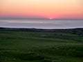 Sunset on seaside Sheep on hill sun nearly gone