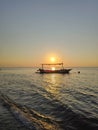 The sunset that seems to be anchored using this small boat.