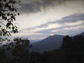 Sunset seen from viewpoint with cluody sunset sky,distant mountains in the background and forest in the foreground. Karnataka,