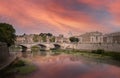 Sunset sene of St. Angelo Bridge over River Tiber in Rome, italy under red dramatic sky Royalty Free Stock Photo