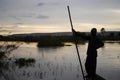 Sunset Shilouette Of An African Fisherman Standing In His Boat Holding A Push Pole Royalty Free Stock Photo