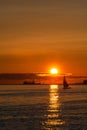 Sunset with ship silhouette and sailboat