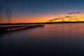 Sunset on the shore of the lake with a footbridge Royalty Free Stock Photo